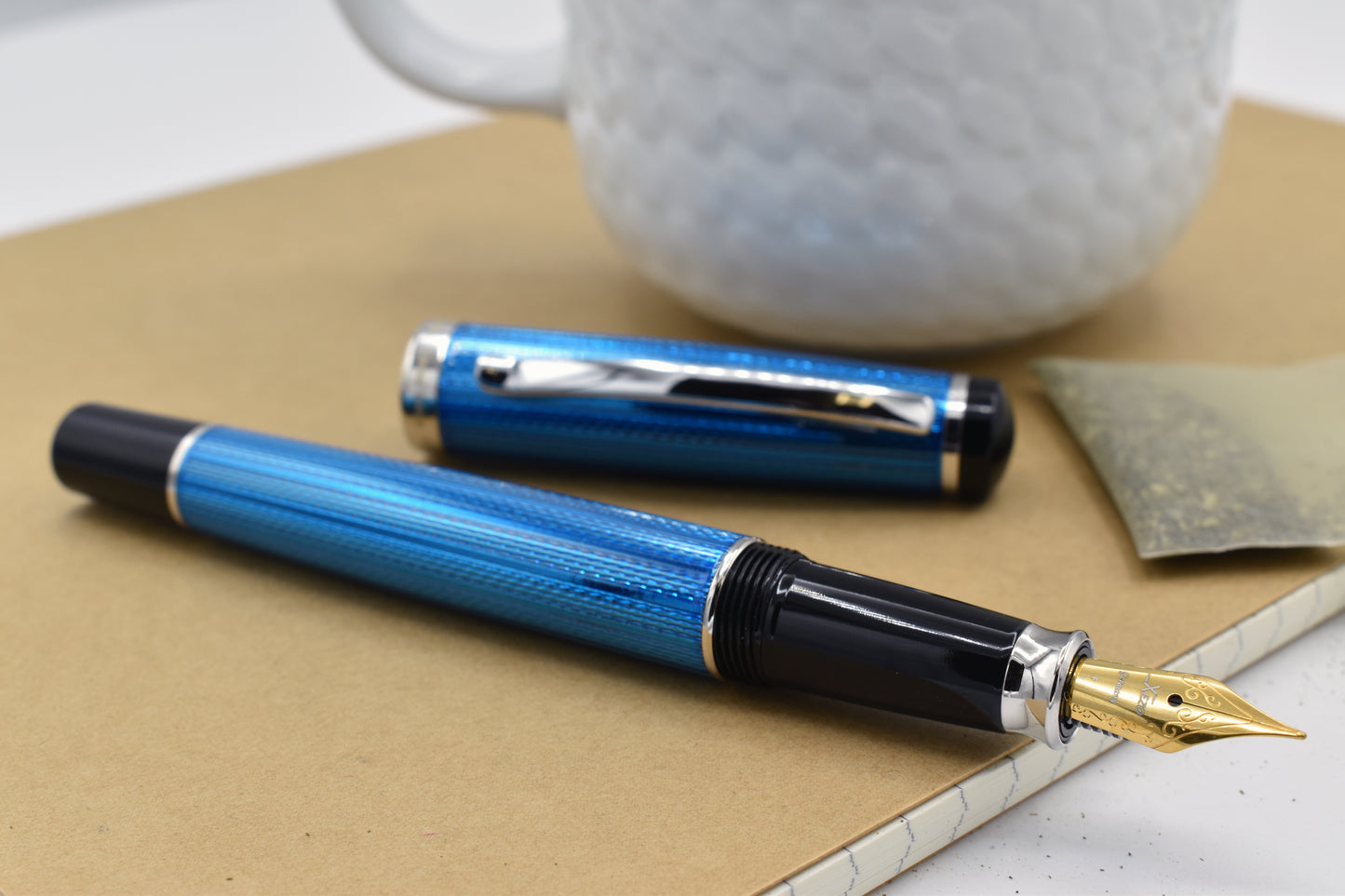 Incognito Blue F-1 Fountain pen next to a mug
