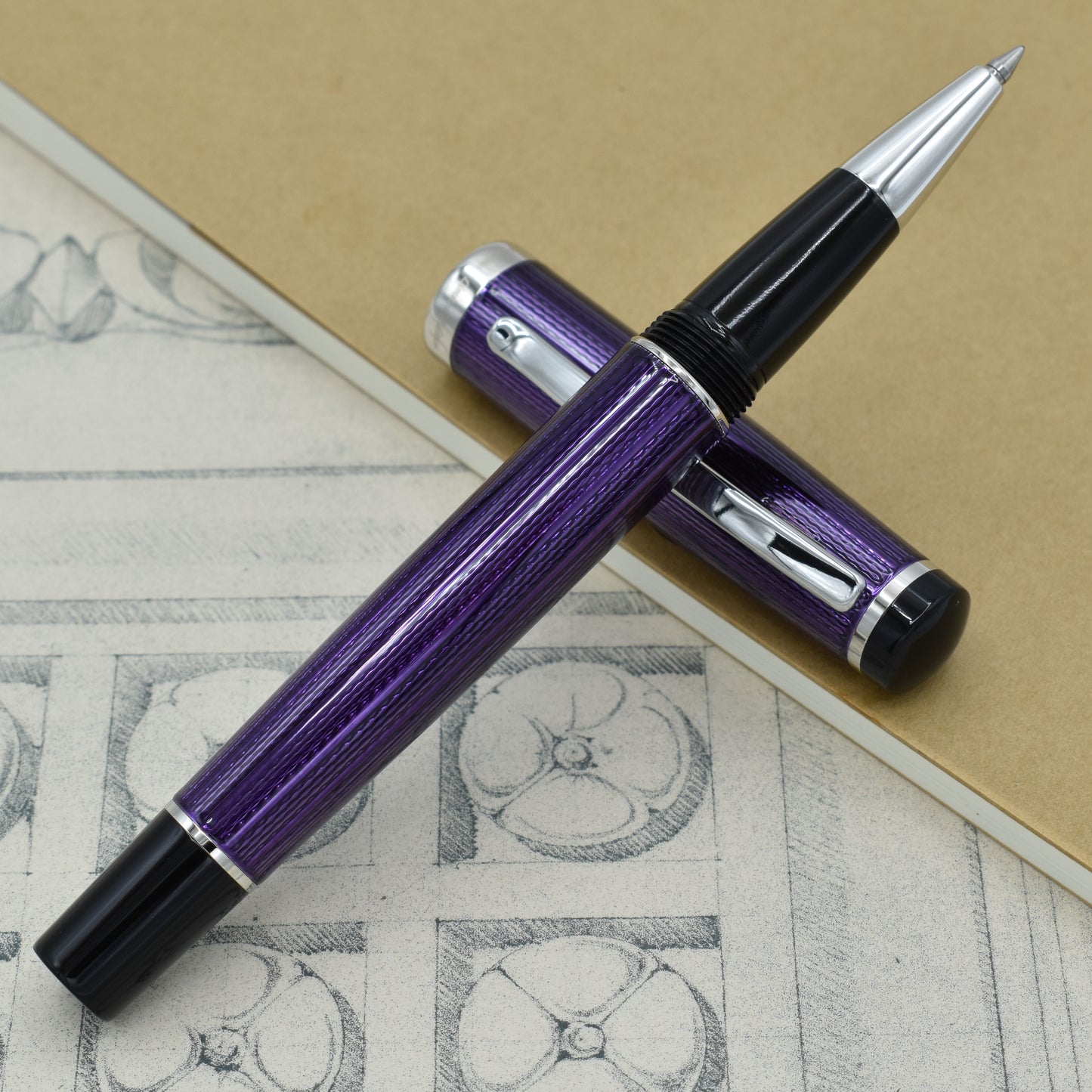 Incognito Purple R Rollerball pen with antique architectural sketches and a notebook