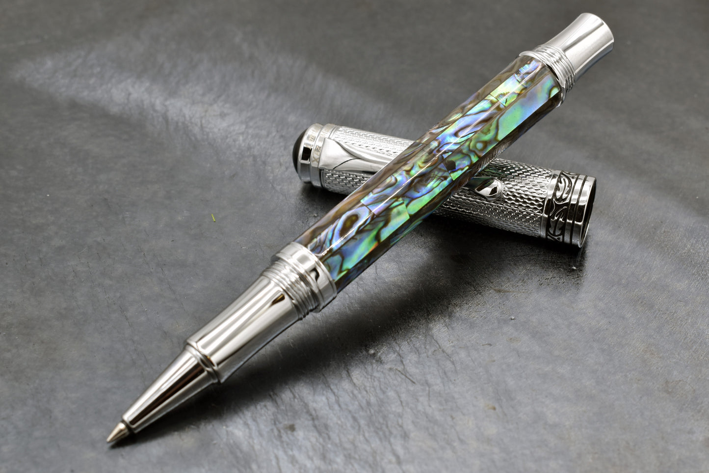 Maestro Paua Abalone Chrome R Rollerball pen on a dark background