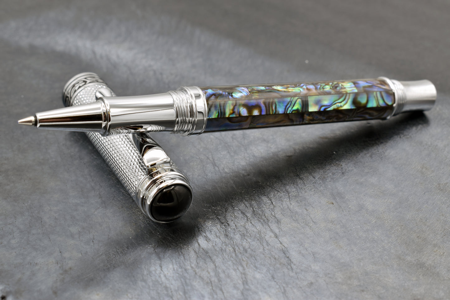 Maestro Paua Abalone Chrome R Rollerball pen on a dark background