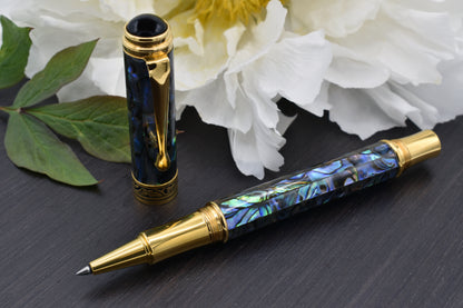 Xezo - Uncapped angled 3D view of the front of the Maestro Sea Shell RPG-1A Rollerball pen with a white peony flower