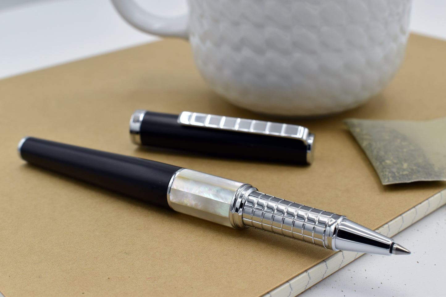 Speed Master Black R-WC Rollerball pen next to a mug