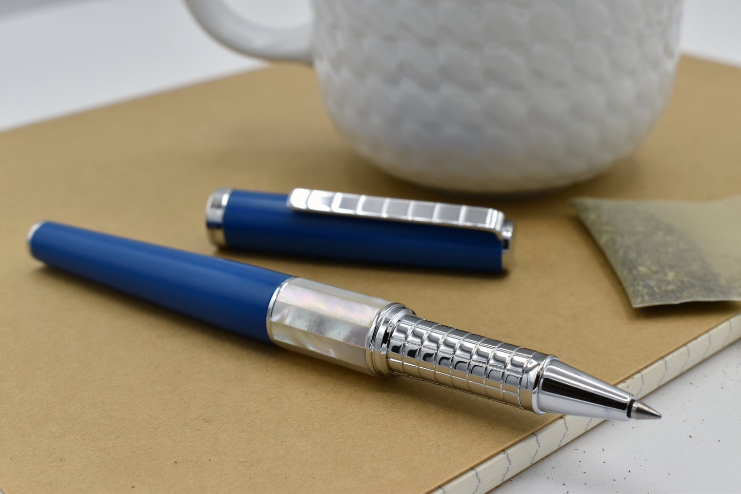 Speed Master Lapis Blue R-WC Rollerball pen next to a mug