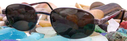 Xezo - Angled view of the front of a pair of Airman 3400 sunglasses on colorful stones