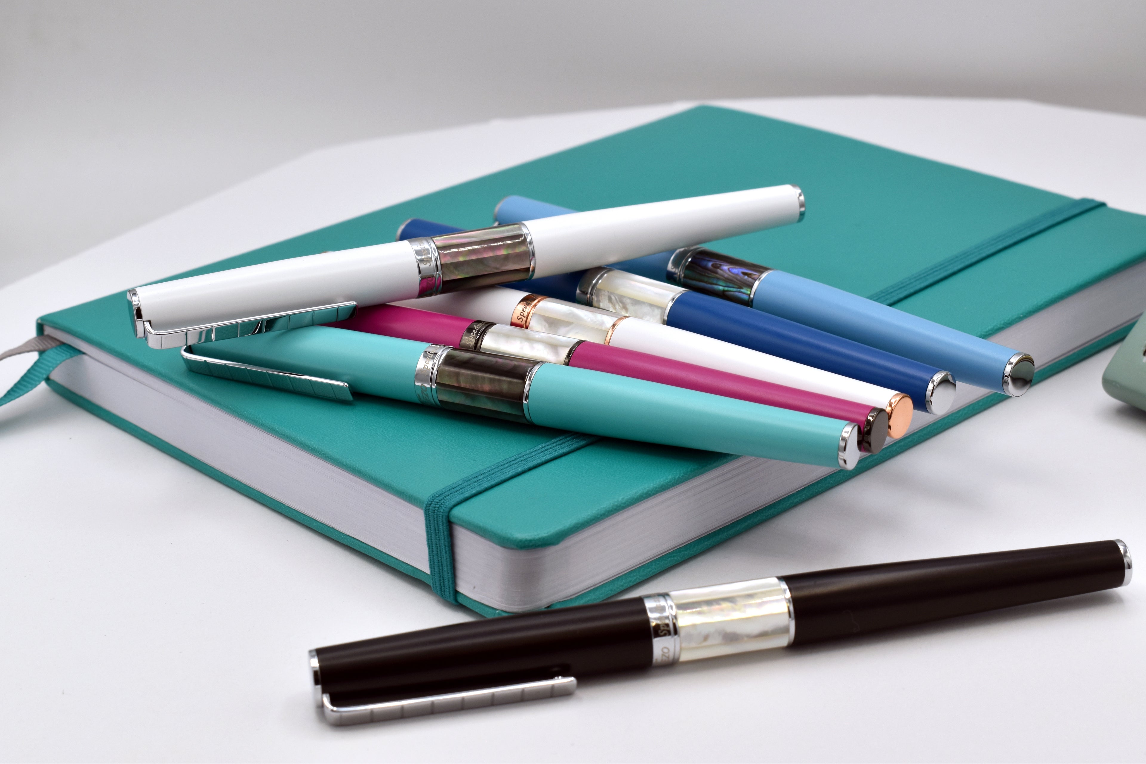 Assorted Xezo Speed Master Pens laid on a notebook