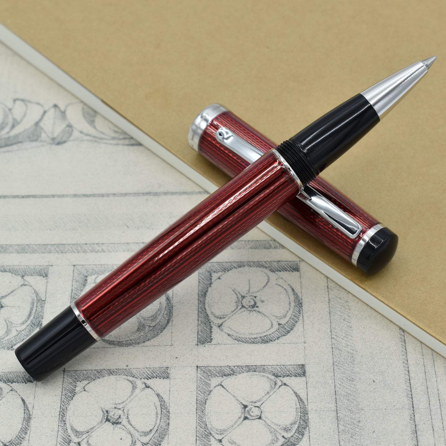 Incognito Burgundy R-1 Rollerball pen with antique architectural sketches and a notebook