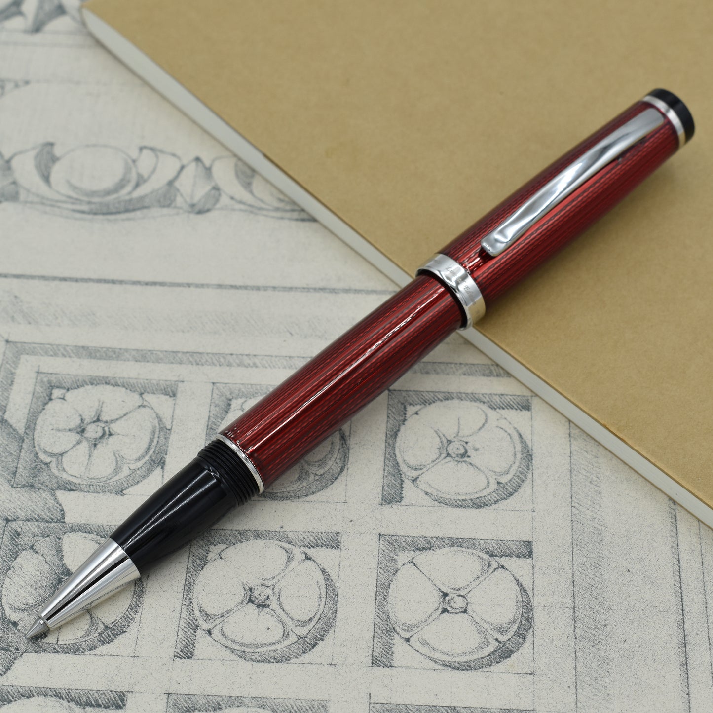 Incognito Burgundy R-1 Rollerball pen with antique architectural sketches and a notebook