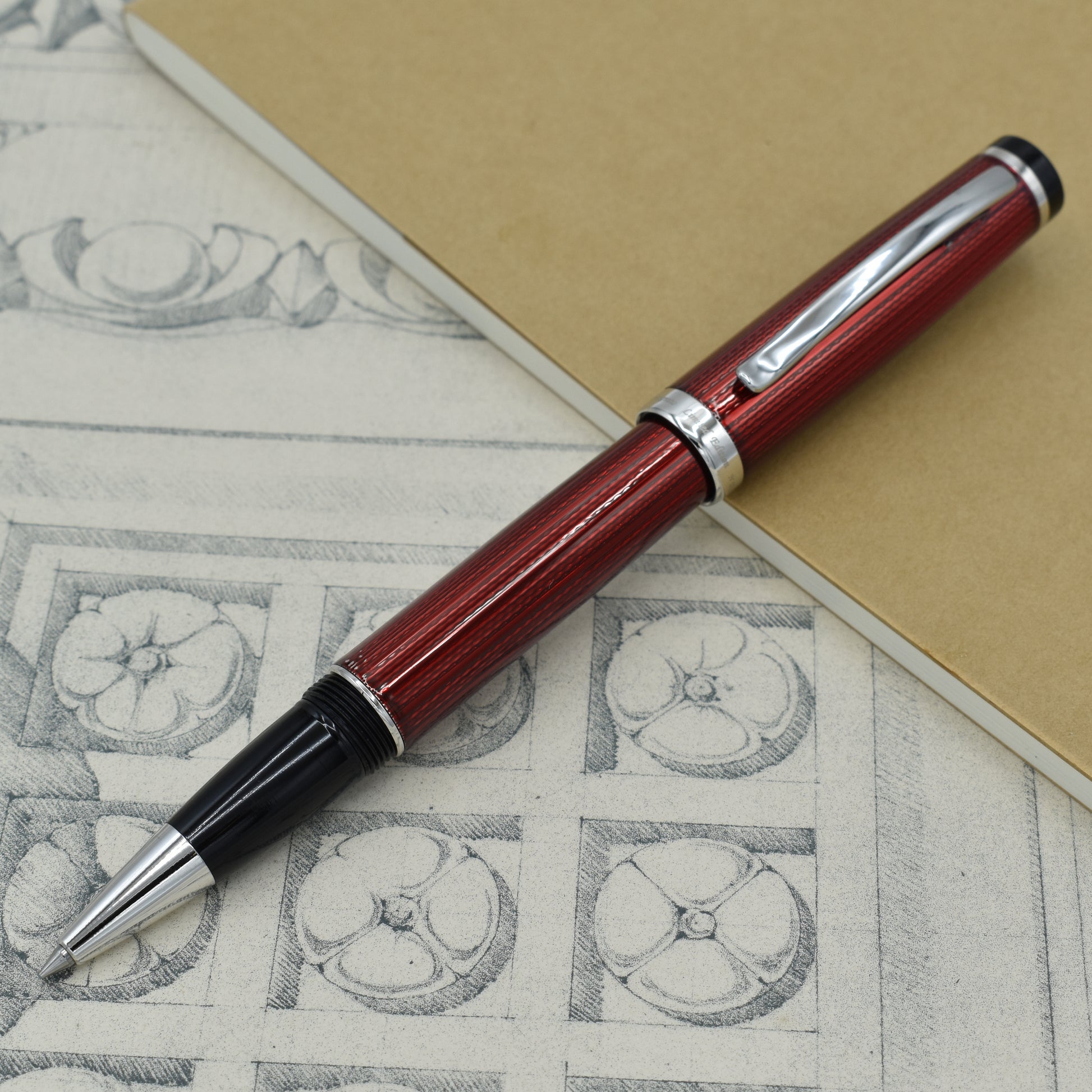 Incognito Burgundy R-1 Rollerball pen with antique architectural sketches and a notebook