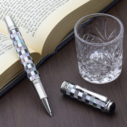 Maestro Jubilee Classic Of The Ocean R Rollerball pen with a book and glass cup