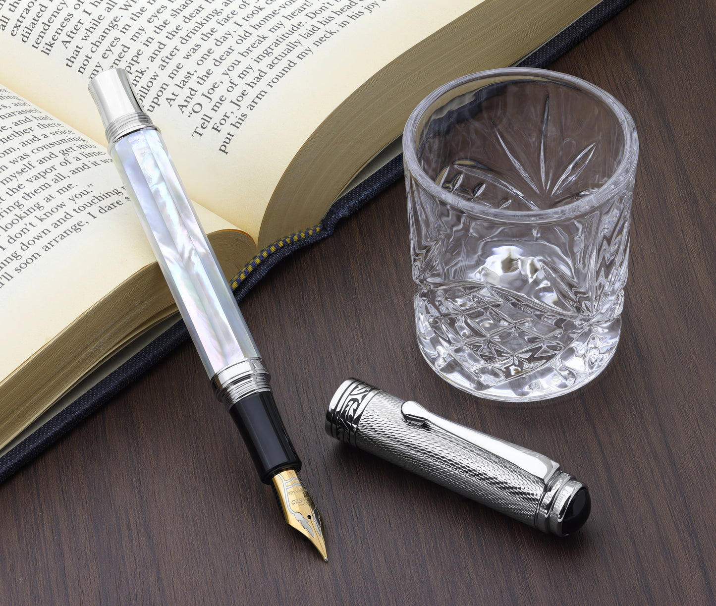 Maestro White MOP Chrome FM-2 Fountain pen with a book and glass cup