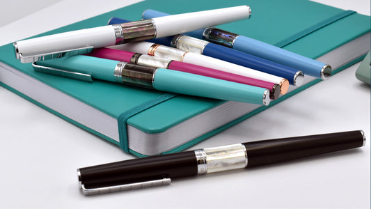 Assorted Xezo Speed Master Pens laid on a notebook