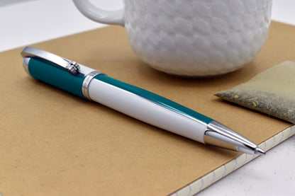 Visionary Teal Green/White B Ballpoint pen next to a mug